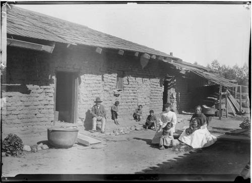 [Mexican] family outside adobe