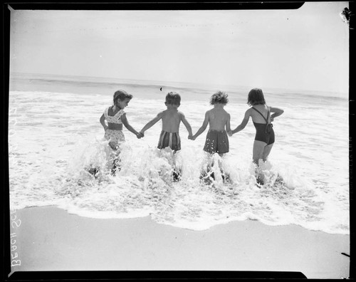 Children holding hands in the surf, Santa Monica