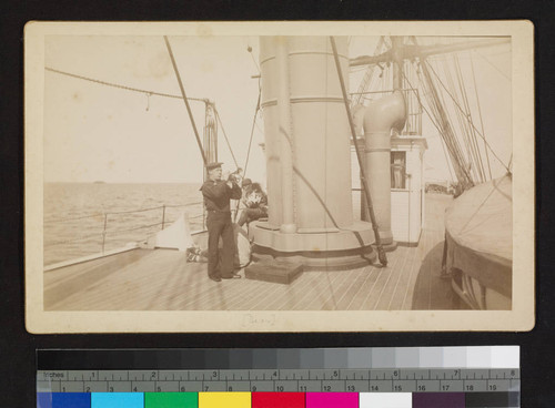 The "Bear"; crewman blowing horn with two men sitting near by