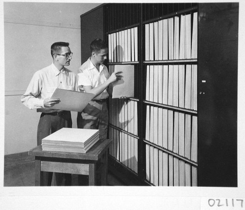 James McClanahan and Hendrik Rubingh filing sky survey plates in a vault room