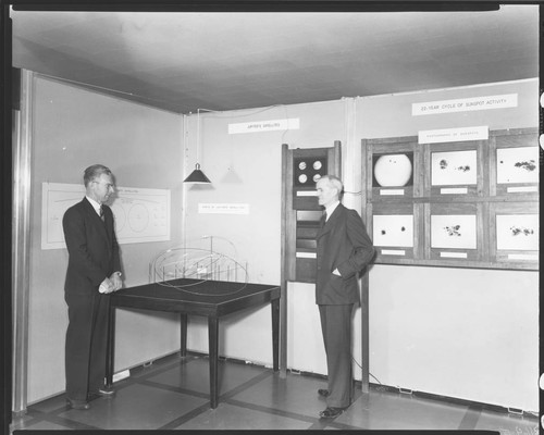Walter S. Adams and Seth B. Nicholson standing by a three-dimensional display of Jupiter's satellites