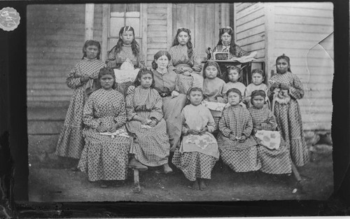 Group portrait of Modoc school girls and teacher showing work being done for the Philadelphia Exposition of 1876