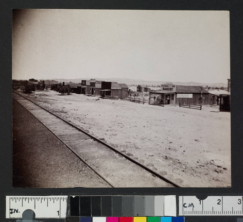 Railroad tracks along a western town with storefronts