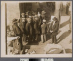 Group of Chinese men in front of easels and market, Old Chinatown, Los Angeles