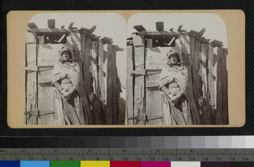 A native woman, most likely Hualapai, stands in front of a wooden shelter