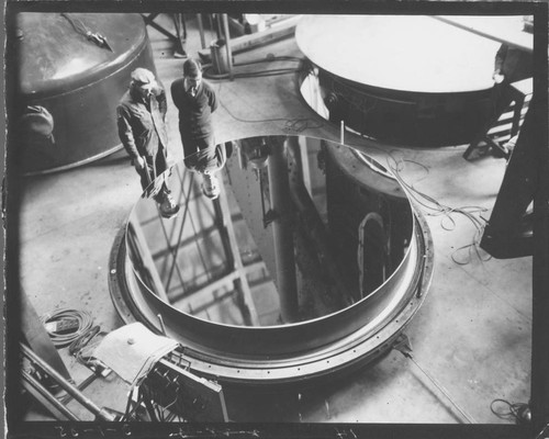 Men inspecting the newly aluminized 100-inch telescope mirror, Mount Wilson Observatory