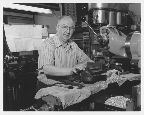 Fred O'Neil standing at a drill press in a machine shop