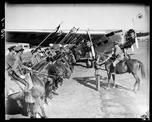 Students from Urban Military Academy on horses lined up next to TWA airplane, Los Angeles, California