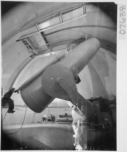 William C. Miller looking through the guidescope of the 48-inch Schmidt camera, Palomar Observatory