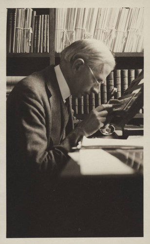 Henry Norris Russell, examining a glass plate in his office