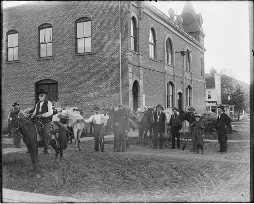 White settlers, some on horseback, in unidentified town