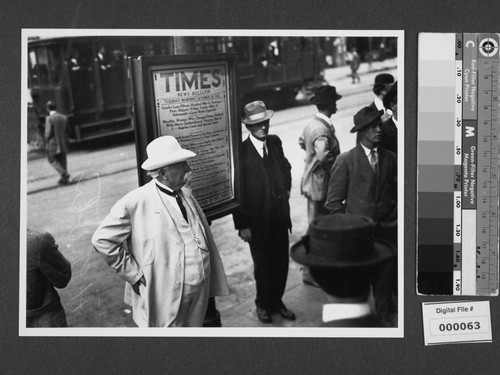 Harrison Gray Otis standing in front of Times News Bulletin board