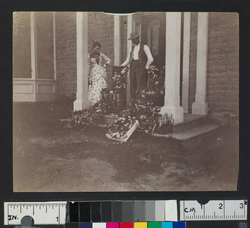 A man and woman with flowers strewn over chairs