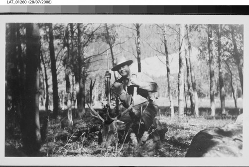 Hunter kneels with dead elk