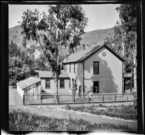 Unidentified two-story house with fenced yard