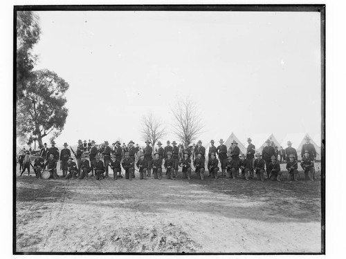 Rifle team in a park with tents