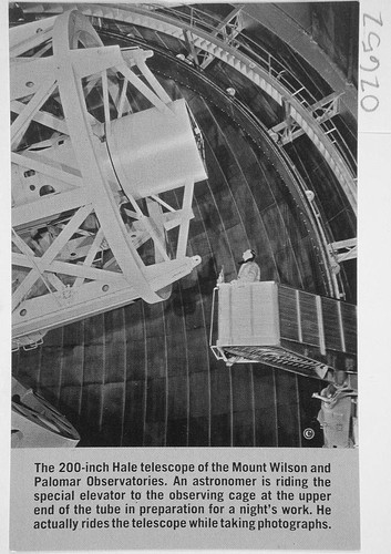 Photograph of a newspaper clipping showing an astronomer in an elevator adjacent to the 200-inch Hale Telescope, Palomar Observatory