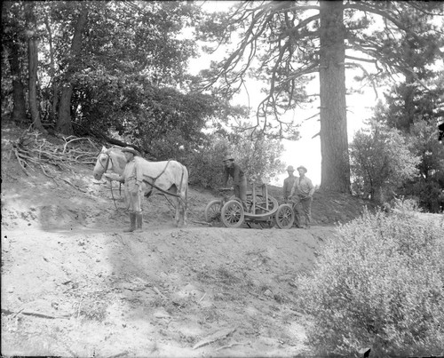 Construction workers with horse-drawn cart, carrying engine wheel