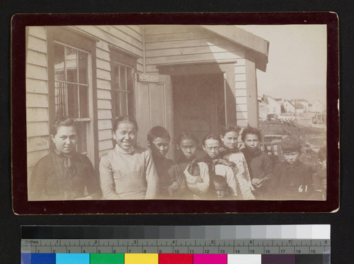 Children, possibly native, next to possibly a school