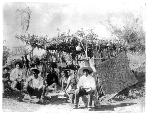 Yaquis at home before a brush hut, Mexico