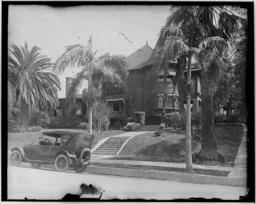 View of house on a residential street and car parked in front