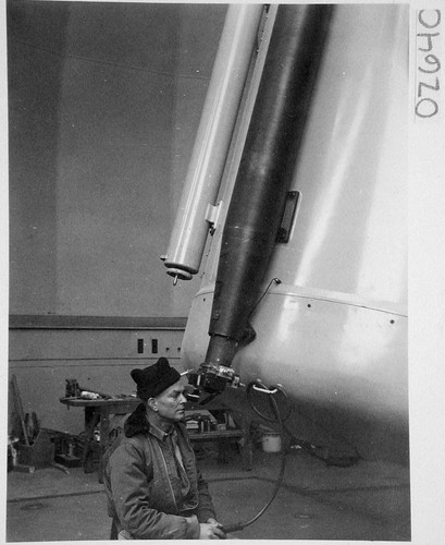 Astronomer looking through guidescope of the 48-inch Schmidt camera, Palomar Observatory