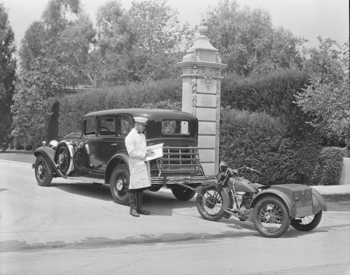 Automobile with motorcycle and delivery man. 1931