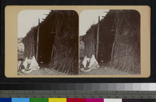 A Cahuilla woman using a low stone mortar and pestle (or metate)