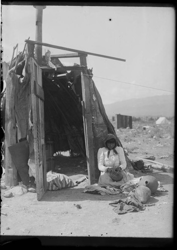 Young married Paiute woman weaving water bottle. Near Sparks, Nevada, 1910