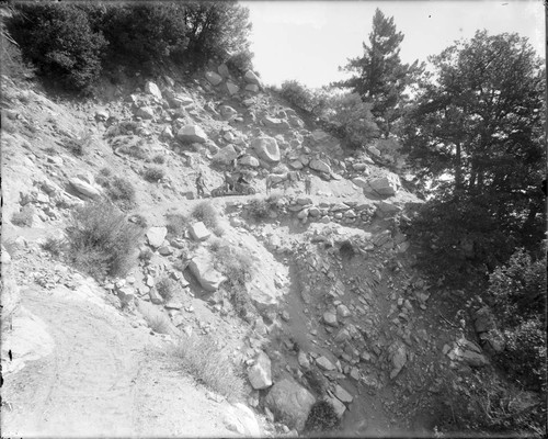 Three men with a horse-drawn cart on a mountain road