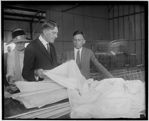 Curtis D. Wilbur and Donald Douglas inspecting parachute at Douglas Company factory, Santa Monica, California