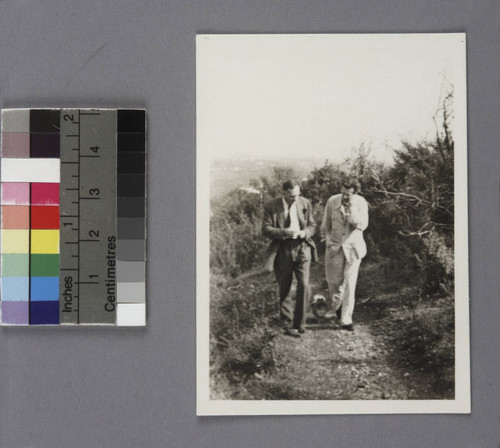 Edwin Powell Hubble and Aldous Huxley walking outdoors with Huxley's dog