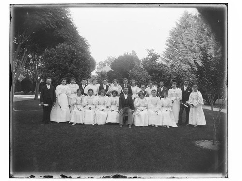 Young men and women with diplomas in park