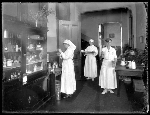 Nurses filling trays with medicine. approximately 1918