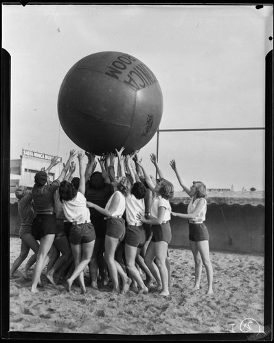 Women tossing giant La Monica Ballroom ball, Santa Monica