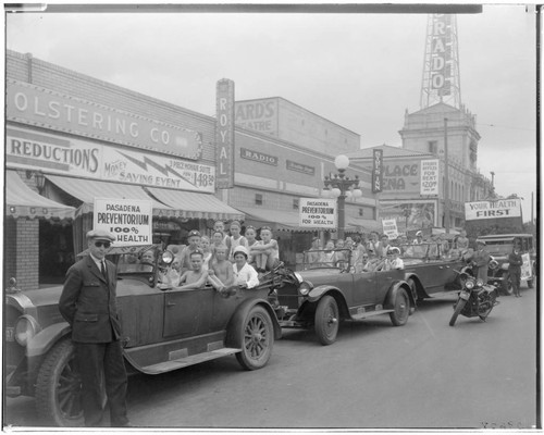 Cars filled with young people in parade on Colorado Street East of Lake Avenue, Pasadena. 1927