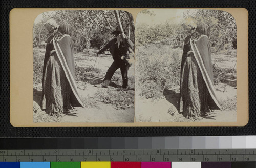 Hualapai Indian woman drinking water from a pottery jar while a man stands nearby