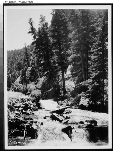 View of a small river flowing at the base of a slope on Vermejo Ranch