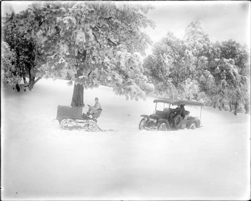 Tractor clearing snow on Mount Wilson, followed by a car