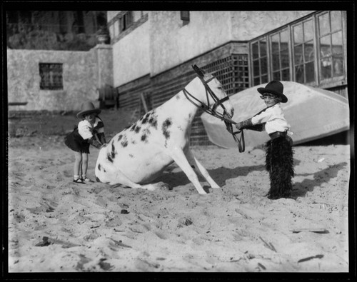 Two members of Meglin Kiddies with a mule on the beach at Gables Beach Club