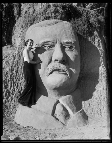 Woman posing with sand carving of Theodore Roosevelt, Santa Monica