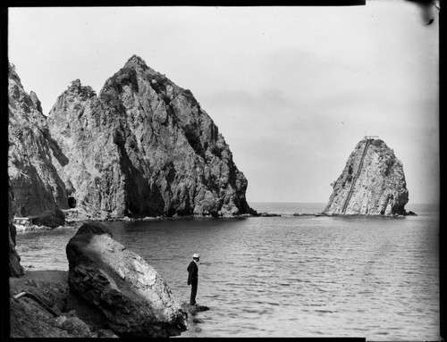 Man on rocks and Sugar Loaf Rock in the background, Catalina Island