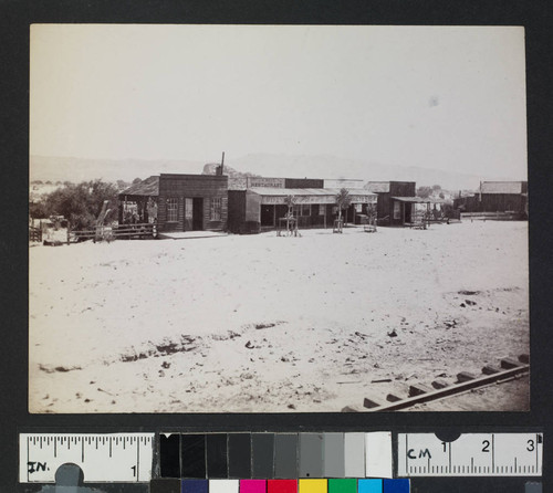 Railroad tracks along a western town with storefronts