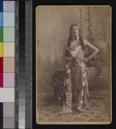 Studio portrait of a Pueblo Indian man holding arrows