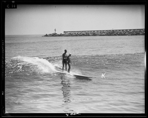 Man and woman riding in on the surf, Santa Monica