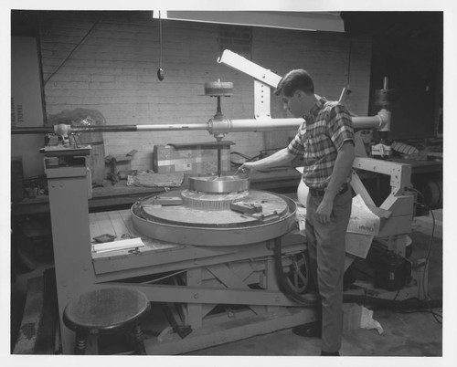 Robert Stiles and the secondary mirror for the Palomar 60-inch telescope on a small grinding machine at Hale Observatories' Pasadena machine shop