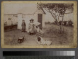 Children in front of playhouse with baby carriage and dog