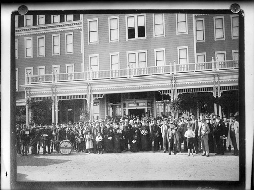 Large group of people, including the Pasadena City Band, in front of a hotel in Pasadena