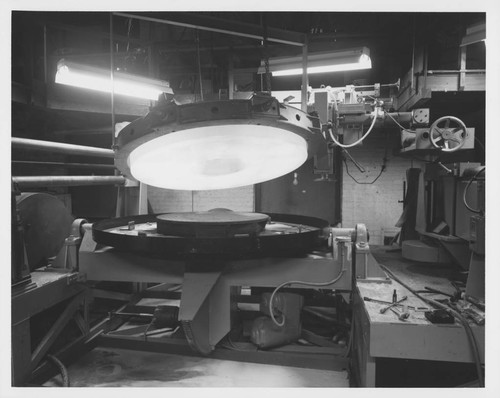 The Palomar 60-inch quartz disk suspended above the grinding machine at Hale Observatories' Pasadena machine shop