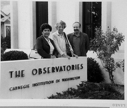 Theodore Dunham and two women standing behind the Mount Wilson and Las Campanas Observatories sign, Pasadena